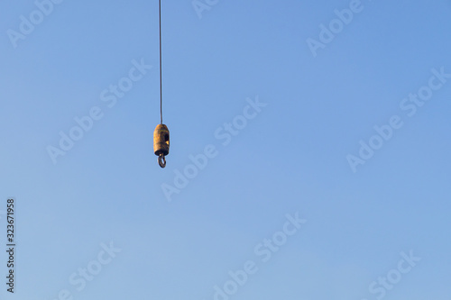 ron hook with iron sling cable of giant crane for lift object on construction site work with blue sky background and copy space