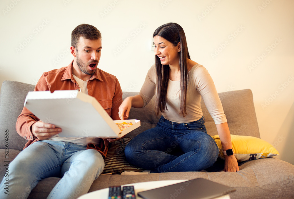 Casual happy couple eating pizza at home Casual happy couple eating pizza at home