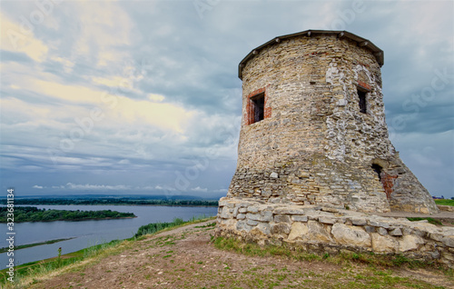 An old medieval watchtower on a steep river bank. A round stone wall made of wild stone. Russia, Tatarstan, the city of Elabuga. photo