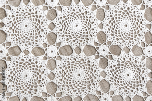 crochet doily, tradional circle knitting background, on a wooden table