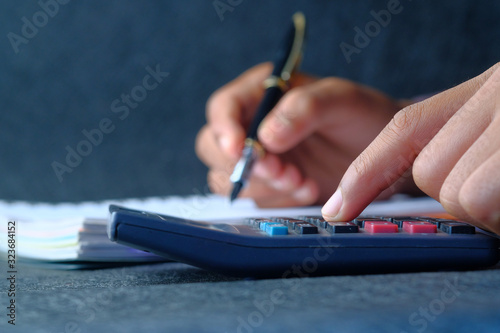 Close up of women hand using calculator on table 