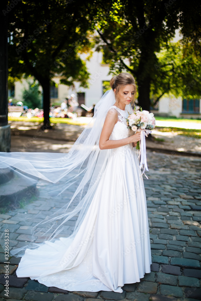 bride full length holding a bouquet of flowers