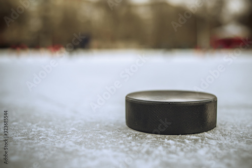 Canvas Print hockey puck lies on the snow close-up