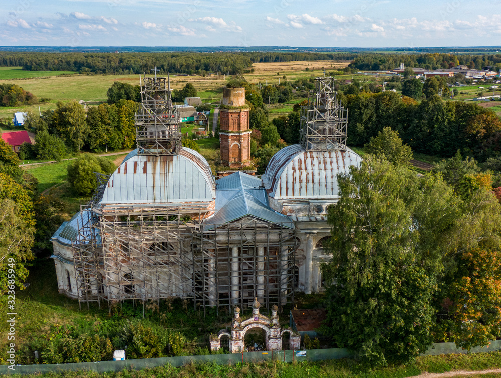 Old destroyed Orthodox church among green trees and fields ...