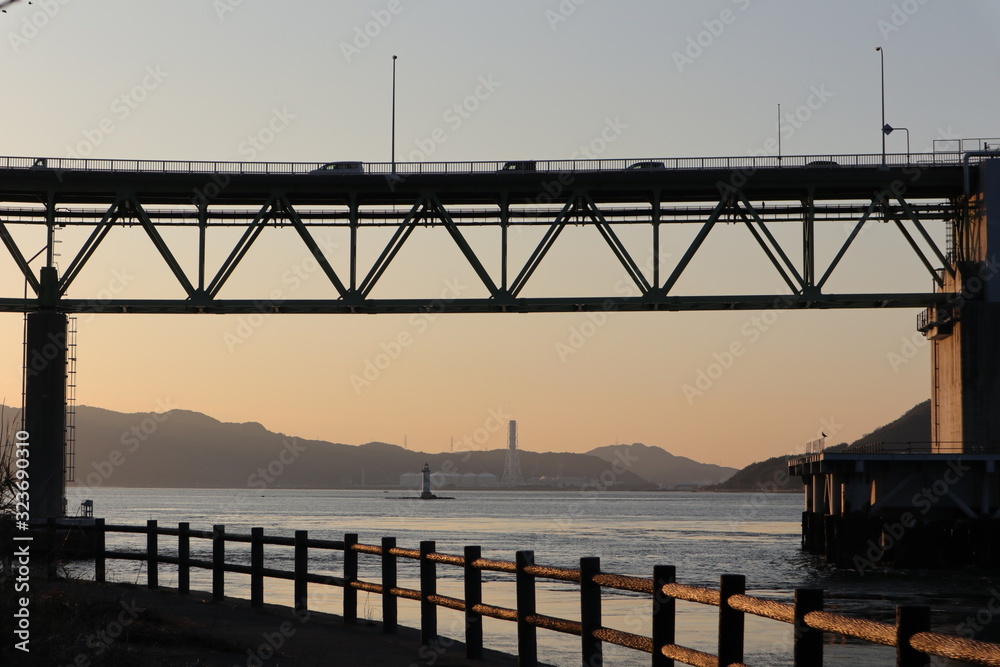 夕景の海と橋と、橋を渡る車