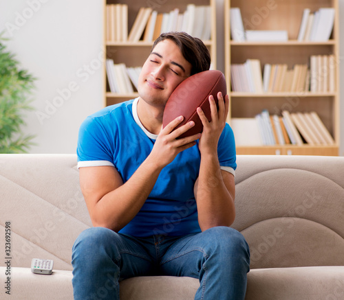 Man watching football at home sitting in couch photo