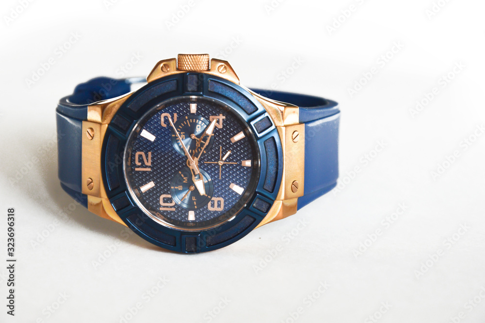 Stylish blue wrist watch on a white background. Round dial in blue and gold colors. Stylish blue wrist watch on a white background. Round dial in blue and gold colors.
