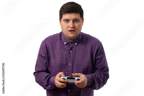 Fat man in a purple shirt plays on the gamepad with an enticed look on a white background. isolate. copy space
