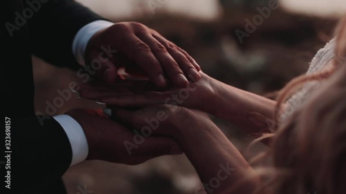 Bride holds wedding rings on her palm, Sunset,