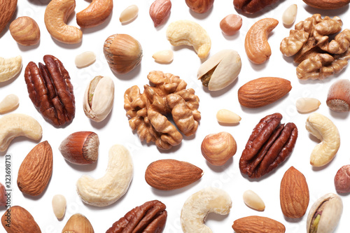 Different delicious nuts on white background, flat lay
