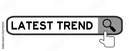Search box with word latest trend and hand icon over magnifier on white background