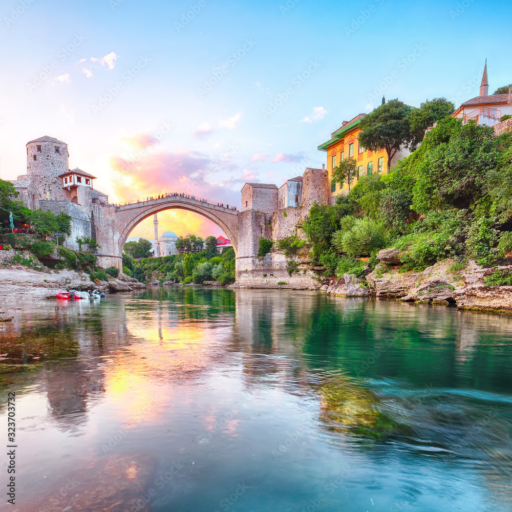 Fantastic Skyline of Mostar with the Mostar Bridge, houses and minarets, at sunset