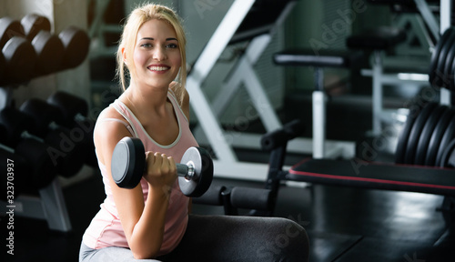 Caucasian women lifting dumbbell workout in a Fitness center or gym. Exercise helps to have a healthy body and beautiful muscles. And without the disease. Concept of health care and playing sports