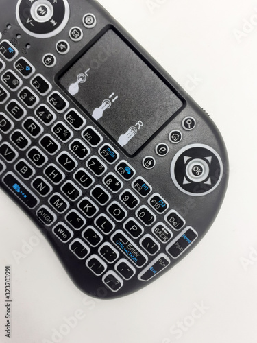 Modern Artistic Black TV Remote with QWERTY Keypad and Game Tools in White Isolated Background © Yudhistira