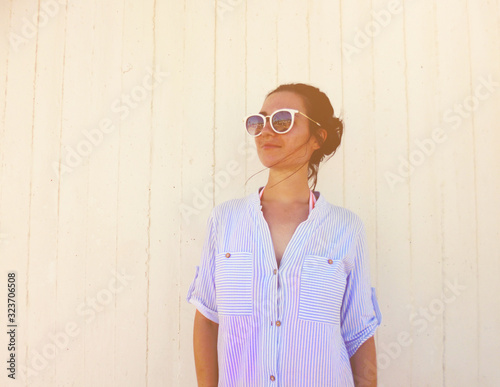 Beautiful woman on wooden backgroundand and sunlight. attractive girl in sunglasses enjoy summer day photo