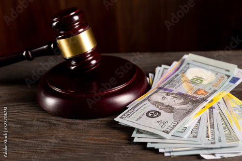 Lawyer and attorney concept. Wooden judge gavel and dollars on the table