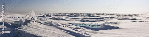 Transparent ice hummock in the snow on Lake Baikal in Siberia, Russia. Wide panorama background