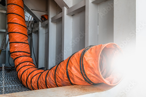 Mobile ventilation fan installed to ventilate air pollution in welding of structural steel working in confined spaces area at site construction. Ventilation system safety concept.