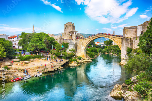 Fantastic Skyline of Mostar with the Mostar Bridge, houses and minarets, during sunny day.