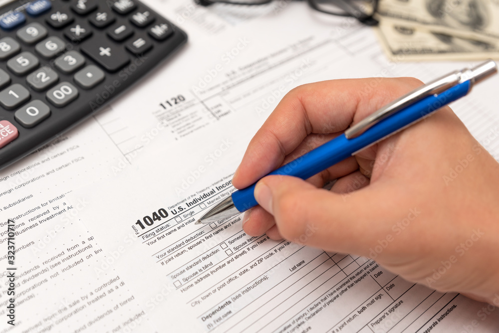 Man filling US tax form in office Man filling US tax form in office