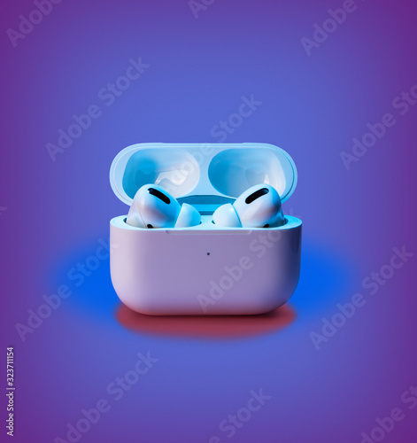 In-ear headphones. Active noise cancellation wireless bluetouth. multicolor backdrop inspired by neon trend. Front view, copy space for your design