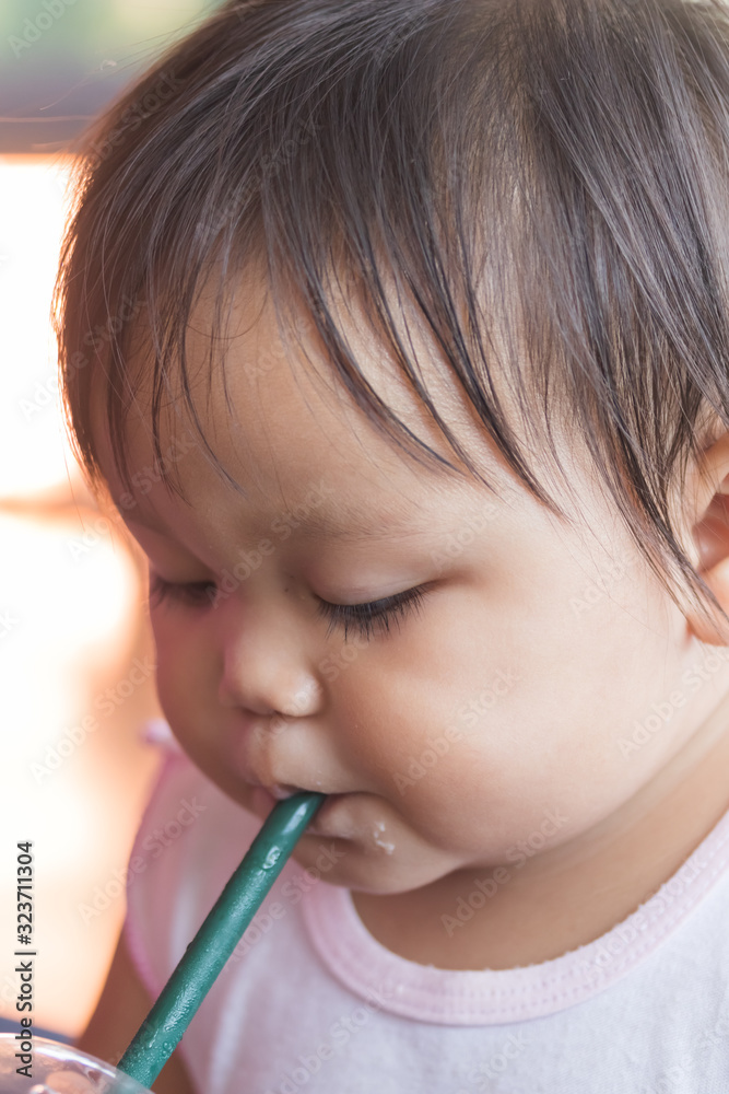 cute little asian girl sucking water from bottles cute little asian girl sucking water from bottles