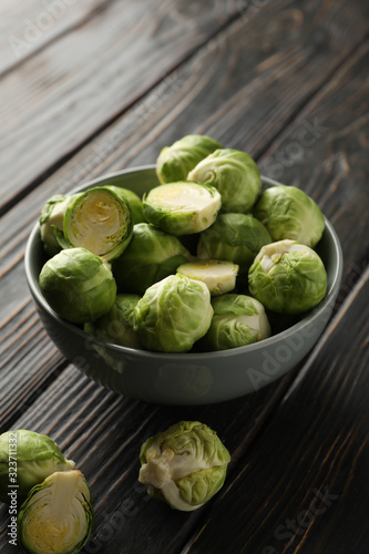 Bowl with brussels sprout on wooden background, space for text
