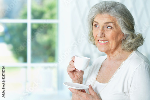 Portrait of beautiful smiling senior woman drinking tea