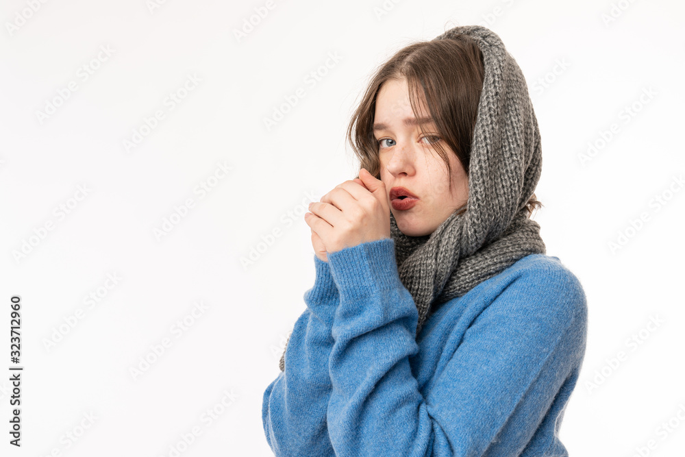 Young european woman isolated on a white background going cold due to low temperature or a sickness, holds her hands near her face and looking at the camera
