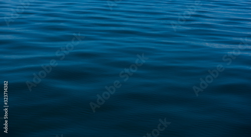 Blue water background with ripples Sea low angle view, Ocean, Wave.   Travel destination and nature environment concept - Ocean water surface texture, summer holiday background © Thanumporn