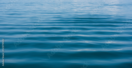 Blue water background with ripples Sea low angle view, Ocean, Wave. Travel destination and nature environment concept - Ocean water surface texture, summer holiday background