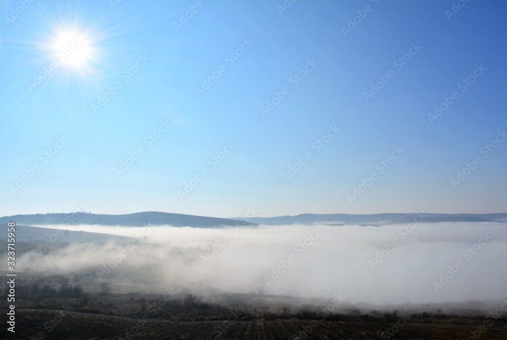 Fototapeta premium fog between hills in a rural area