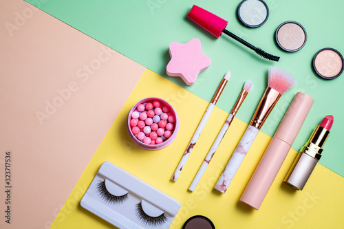 Makeup products and decorative cosmetics on color background flat lay. Set of professional decorative cosmetics. Fashion and beauty blogging concept. Top view, copy space