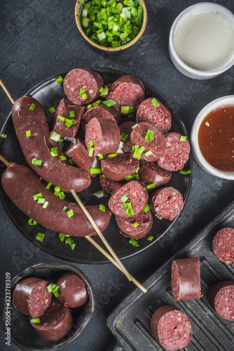 Korean traditional national food. Street home Asian cuisine. Sliced blood sausage soondae or sundae, with rice, noodles, pork meat. With sauces and herbs photo