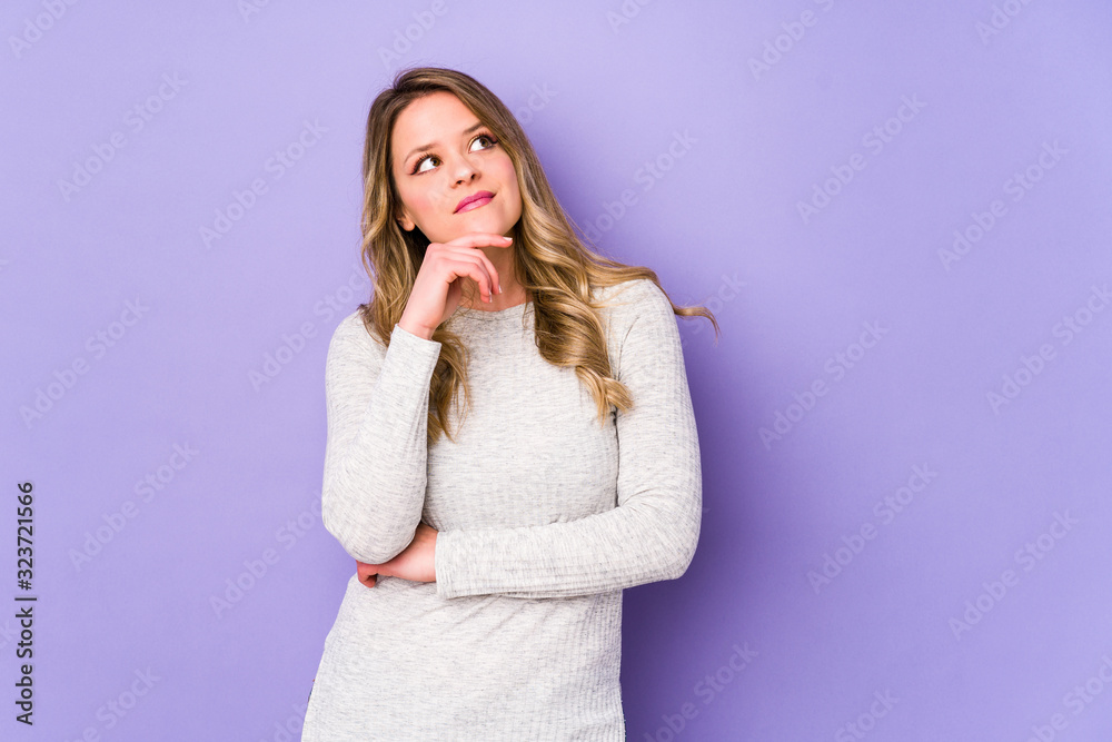 Young caucasian woman isolated on purple background looking sideways with doubtful and skeptical expression. Young caucasian woman isolated on purple background looking sideways with doubtful and skeptical expression.