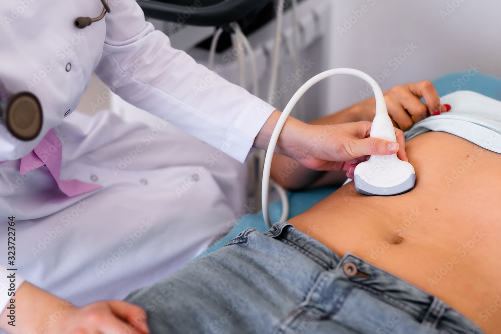 Ultrasound sensor of modern ultrasonic scanner in young woman doctor's hands preparing for a device scan. Helthcare concept Ultrasound sensor of modern ultrasonic scanner in young woman doctor's hands preparing for a device scan. Helthcare concept