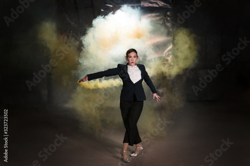 Fototapeta Naklejka Na Ścianę i Meble -  Pasadoble, latin solo dance and contemporary dance - Young beautiful female dancing into smoke cloud