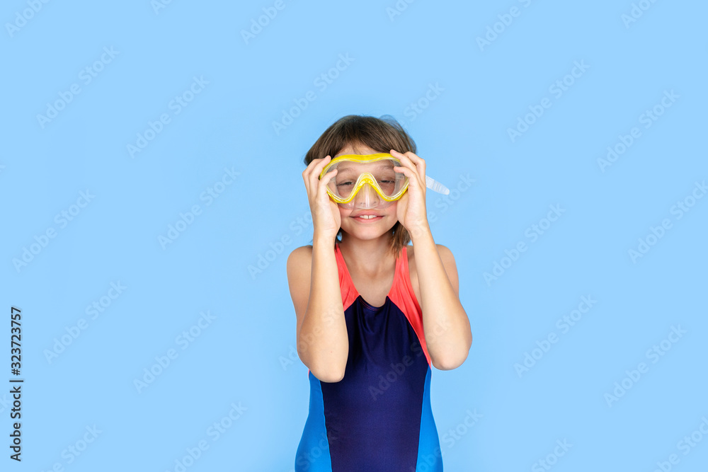 Holiday topic: child girl with snorkeling or diving equipment on a blue background. Adventure and rest concept Holiday topic: child girl with snorkeling or diving equipment on a blue background. Adventure and rest concept