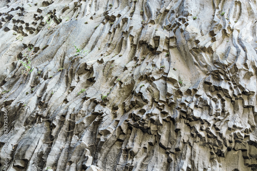 Texture of volcanic stone. Stone slopes of Alcantara Gorge formed by lava of Mount Etna, island Sicily in Italy. Texture of volcanic stone. Stone slopes of Alcantara Gorge formed by lava of Mount Etna, island Sicily in Italy.