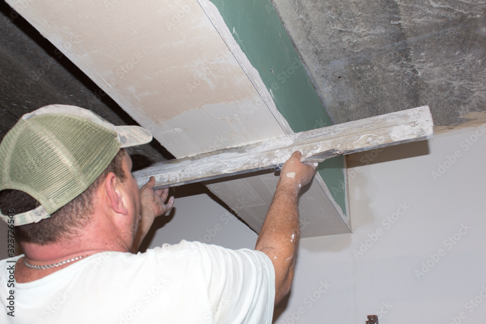 builder smooths the walls with putty