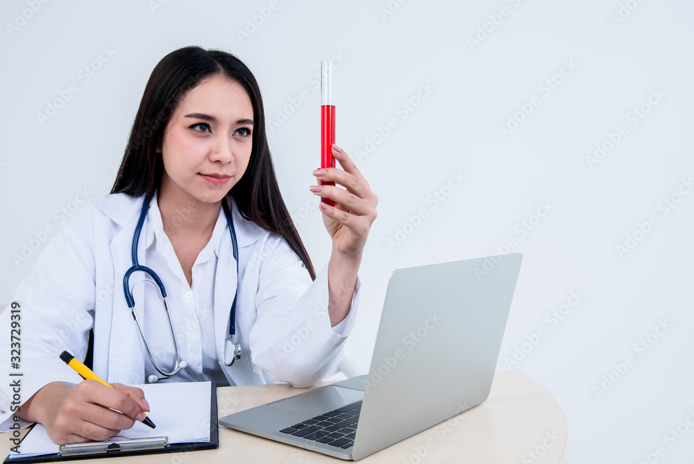 Asian female doctor Looking at the test tube holding in her hand And note the report On white background to health care and science cocnept. Asian female doctor Looking at the test tube holding in her hand And note the report On white background to health care and science cocnept.
