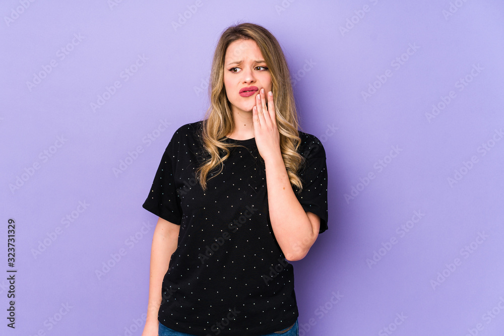 Young caucasian woman isolated on purple background having a strong teeth pain, molar ache. Young caucasian woman isolated on purple background having a strong teeth pain, molar ache.