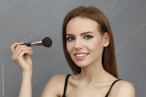 Woman with powder brush in hands