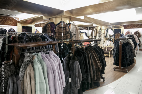 natural fur coats hang on hangers in a store. Sale of winter warm clothes. Turkish shop