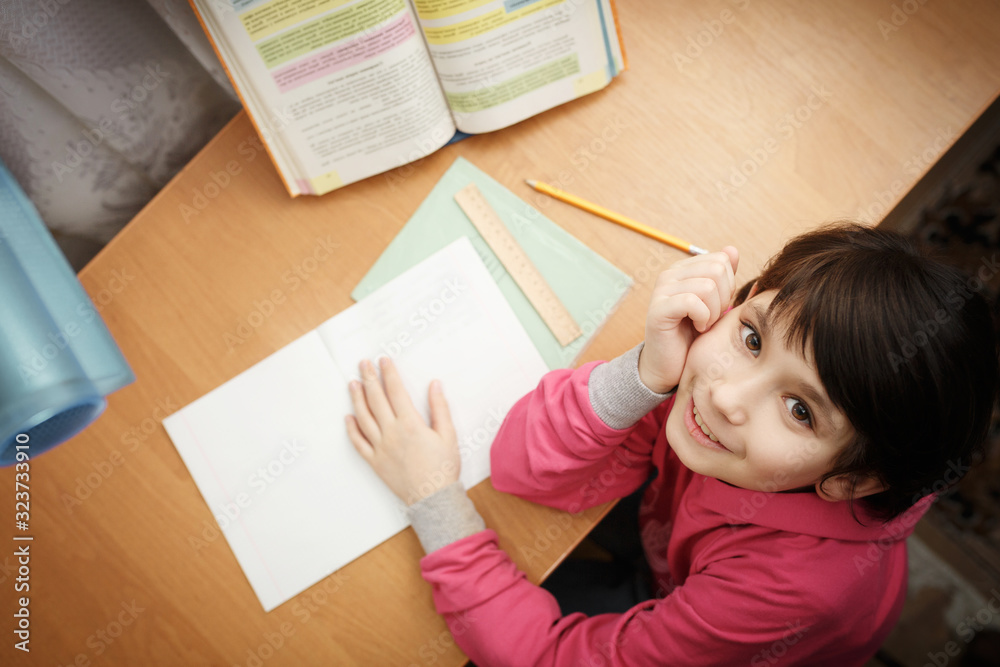 Smiling little asian schoolgirl doing homework. Smiling little asian schoolgirl doing homework.