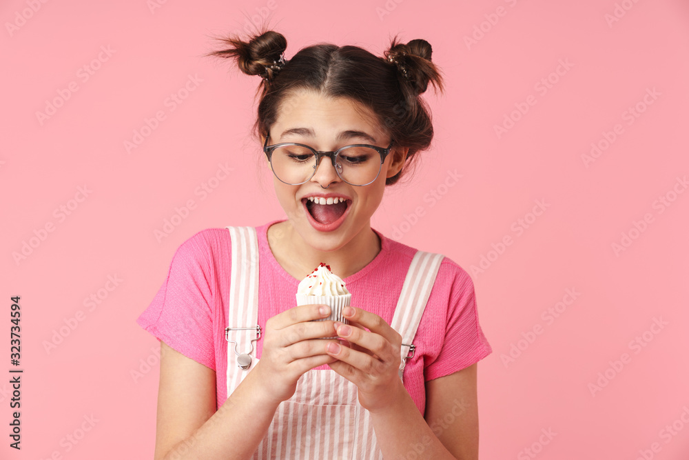 Photo of excited charming girl holding cake and expressing surprise