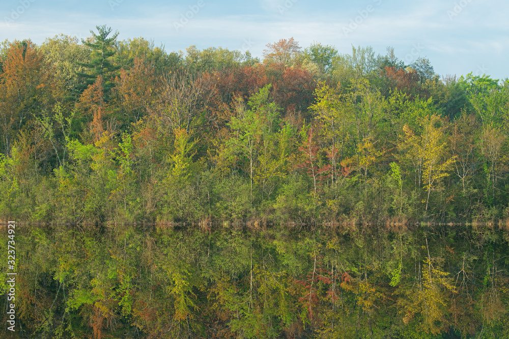 Spring landscape of Long Lake with mirrored reflections in calm water, Yankee Springs State Park, Michigan, USA Spring landscape of Long Lake with mirrored reflections in calm water, Yankee Springs State Park, Michigan, USA