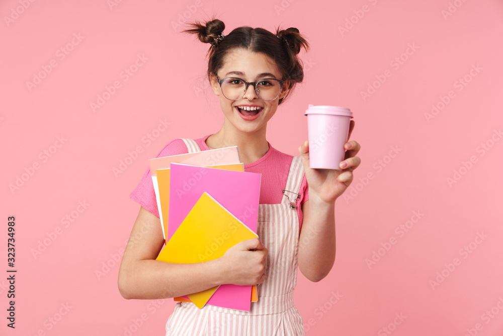 Photo of happy charming girl holding exercise books and paper cup