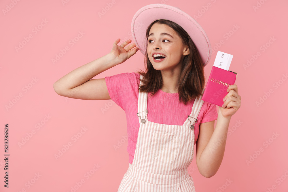 Photo of lovely excited girl in hat holding passport with tickets Photo of lovely excited girl in hat holding passport with tickets