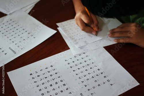 A boy tries to write Japanese characters